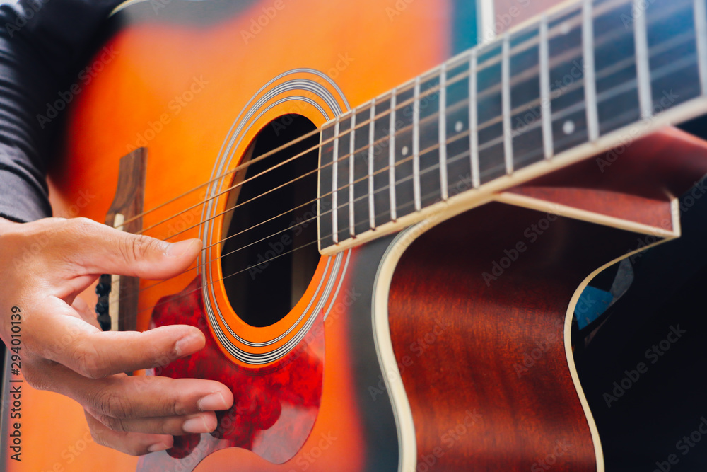Fototapeta premium Man's hand playing acoustic guitar, close up
