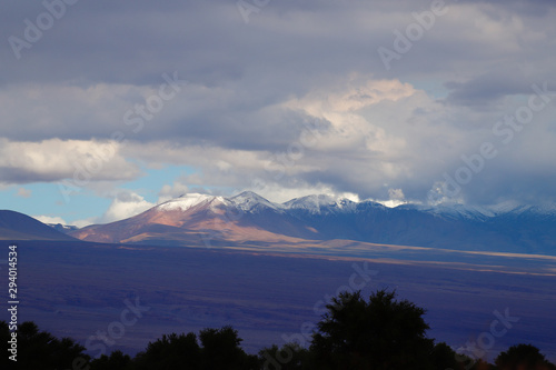 Fototapeta Naklejka Na Ścianę i Meble -  View of the Andean volcanoes covered by clouds and snow, Atacama Desert, Chile
