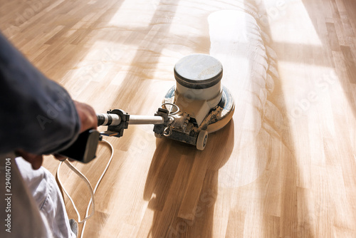a professional master cleans the floor with a polishing machine