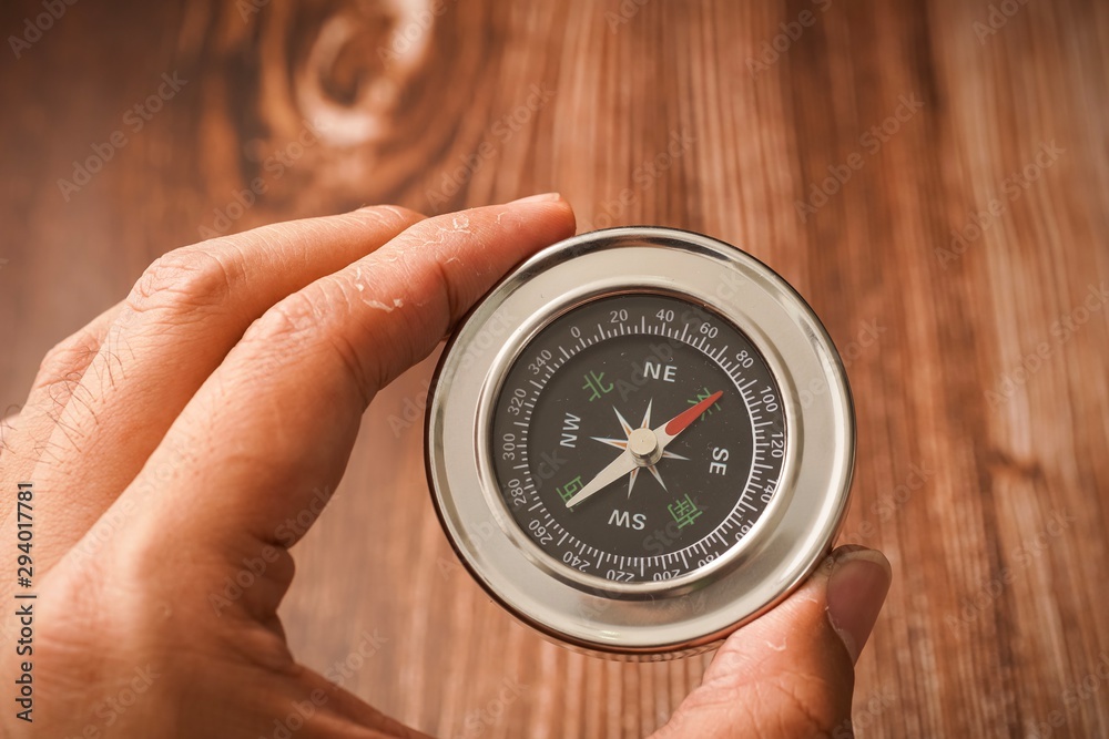 Metallic compass on wooden background Metallic compass on wooden background