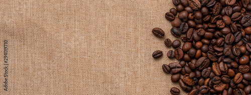 Some fresh roasted coffee beans on a jute cloth, lot of copy space