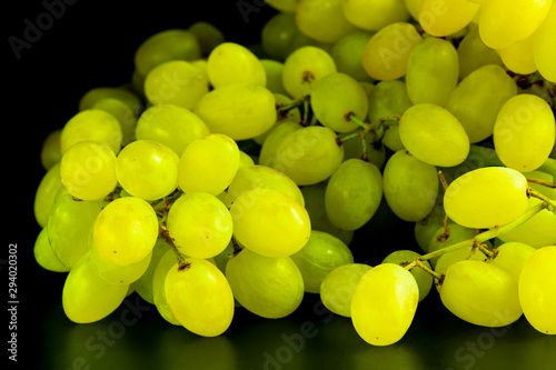 Seedless green grapes on a black background. Autumn Vitamins