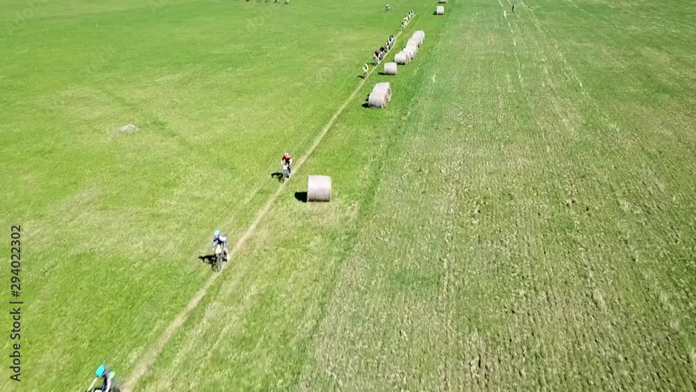 A beautiful fly over of the cyclists into a close up by the hay bales. A steady smooth overhead zoom in to close up. A beautiful fly over of the cyclists into a close up by the hay bales. A steady smooth overhead zoom in to close up.