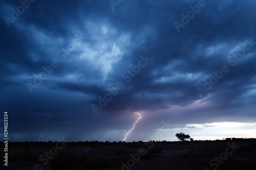 Lightning during a severe thunderstorm in the sunset light in the arid landscape of the Atacama desert, Chile