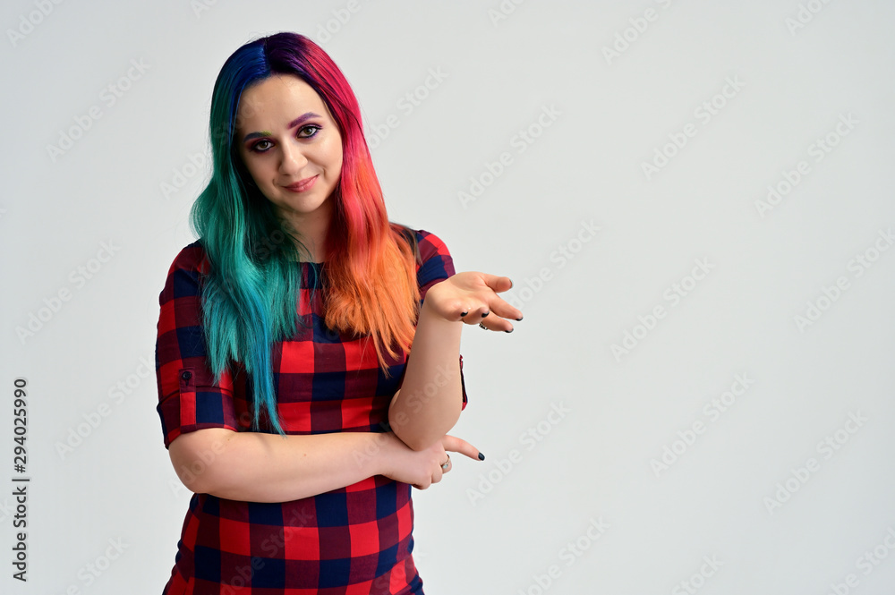 Portrait of a pretty girl with multi-colored hair and make-up on a white background. Stands with a smile in various poses in the studio.