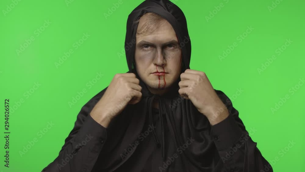 Man executioner Halloween makeup and costume. Guy with blood on his face Man executioner Halloween makeup and costume. Guy with blood on his face