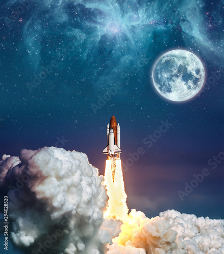 Fototapeta Naklejka Na Ścianę i Meble -  Cloudy launch of rocket Space Shuttle into colorful starry outer space and the full moon. 