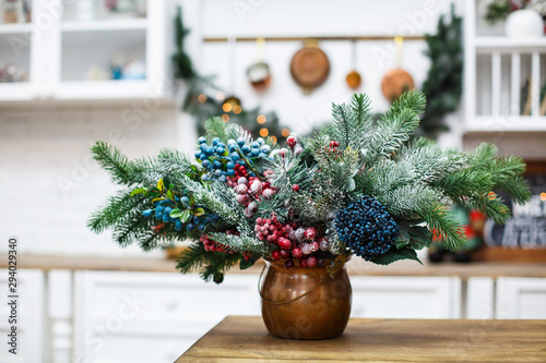 Natural Christmas composition from spruce branches and berries in the kitchen