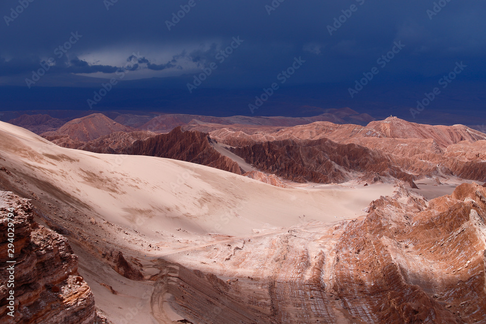 Storm clouds in the landscape of the Atacama Desert. The rocks of the Mars Valley (Valle de Marte) and Cordillera de la Sal, Atacama Desert, Chile