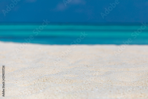 Beach closeup. Sand and blue sea with sky. Tranquil tropical scenery, relaxing beach mood for summer vacation or travel design