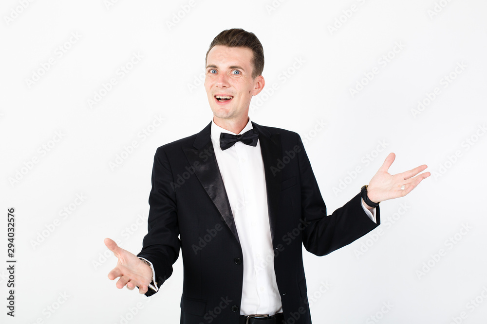 Man toastmaster appeals to the viewer. Young man master performing on the stage. Smiling man on white background with copy space Man toastmaster appeals to the viewer. Young man master performing on the stage. Smiling man on white background with copy space