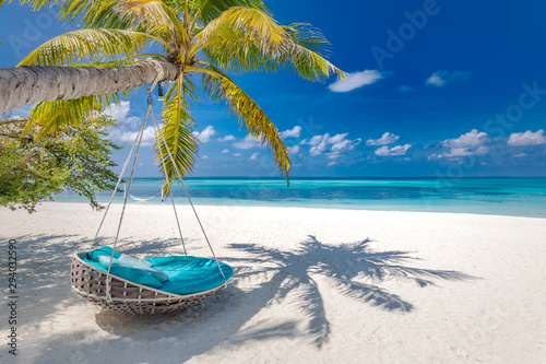 Summer beach background as summer landscape with beach swing or hammock and white sand and calm sea for beach banner. Perfect beach scene vacation and summer holiday concept. Boost up color process