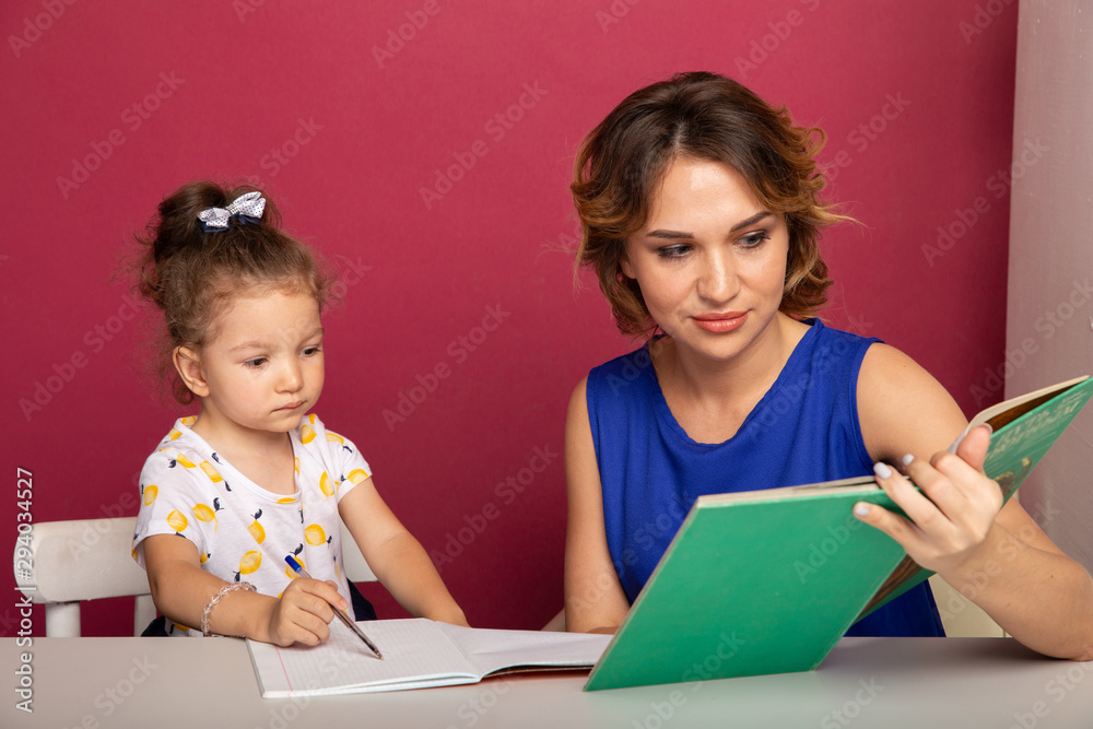 Female tutor with little girl doing homework. Preschool concept Female tutor with little girl doing homework. Preschool concept