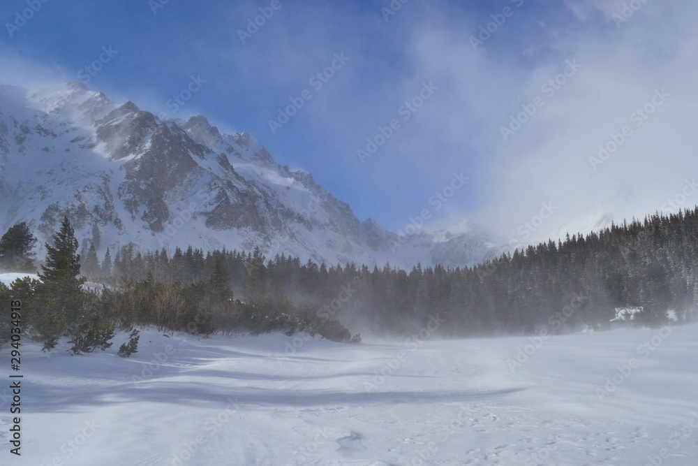 Popradske pleso in winter. Sunny day, white clouds, beautiful mountains. High Tatras, Slovakia.