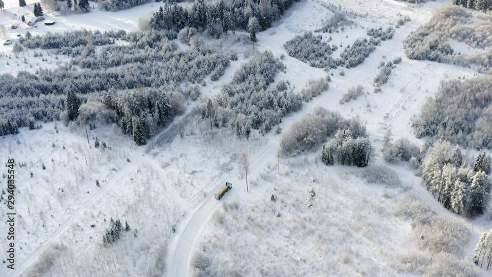 The aerial view of the big truck travelling on the road in the forest The aerial view of the big truck travelling on the road in the forest