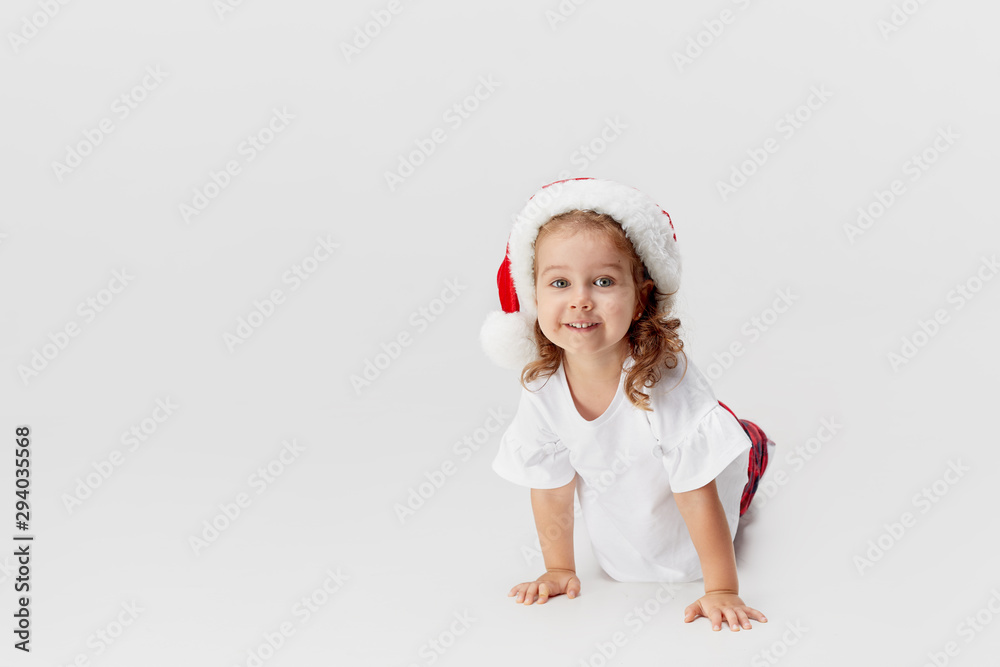 Portrait of little child girl in Santa hat having fun isolated on white background. Christmas and new year concept.