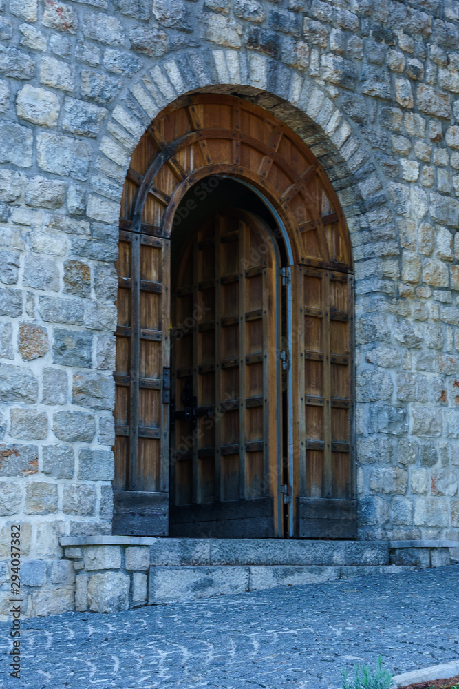 High vaulted doors in the stone wall of an old building.