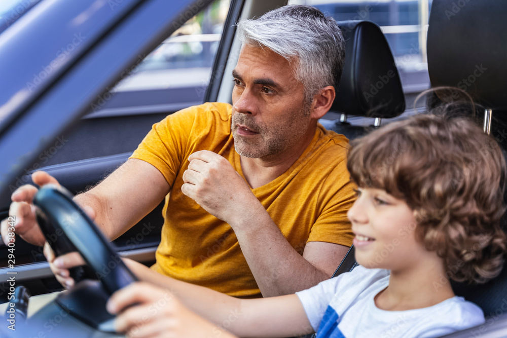 Handsome man teaching his son how to drive Handsome man teaching his son how to drive