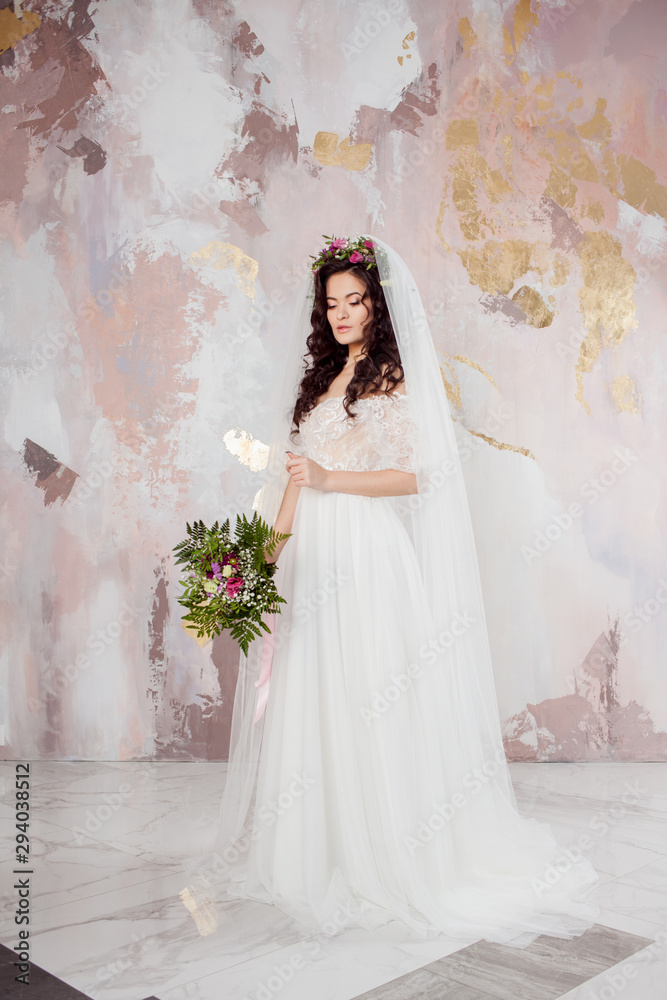 Beautiful young bride in wedding dress with veil on her face Beautiful young bride in wedding dress with veil on her face