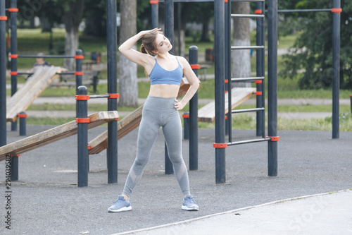 Female person doing exercises outdoor on the street