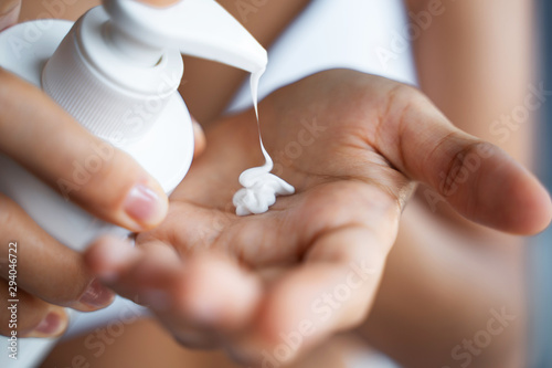 Woman hands applying a moisturizing hand lotion photo