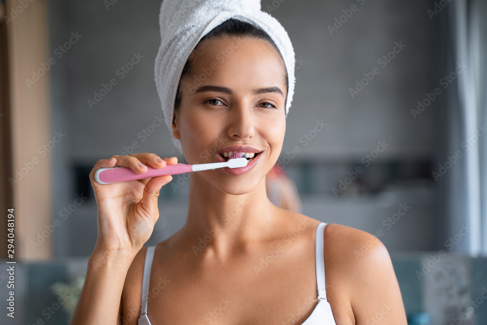 Smiling girl cleaning the teeth in the bathroom Smiling girl cleaning the teeth in the bathroom