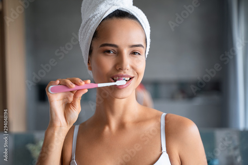 Smiling girl cleaning the teeth in the bathroom