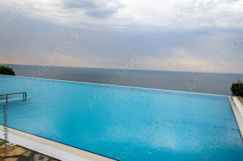 Infinity pool with crystal blue water view to sea  ocean © Negoi Cristian