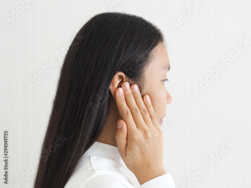 ruptured eardrum,tinnitus and meniere disease and otitis media in asian woman. She use hand touching her ear causes of ear pain on white background use for health care concept.