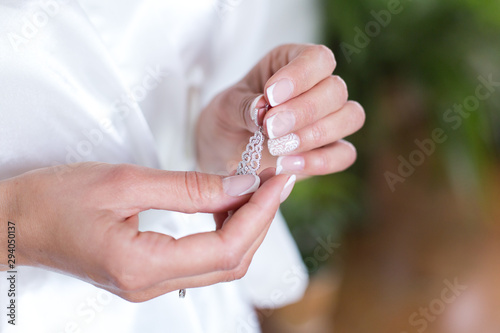 Beautiful woman's hands with perfect manicure with silver earring