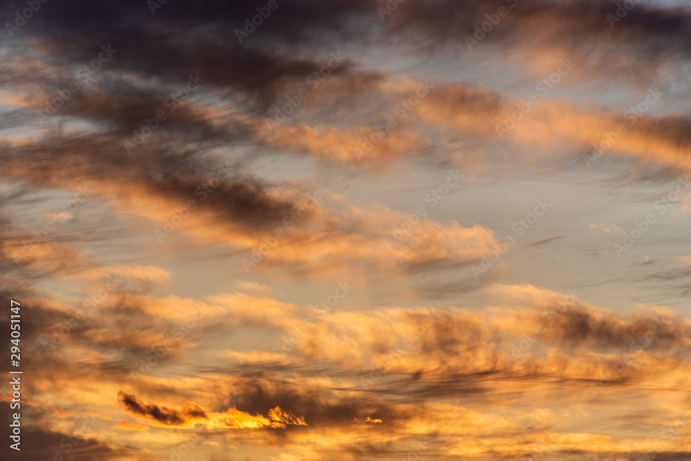 Sunset with cloudy sky, cirrus clouds, blues, oranges and yellows, nature background