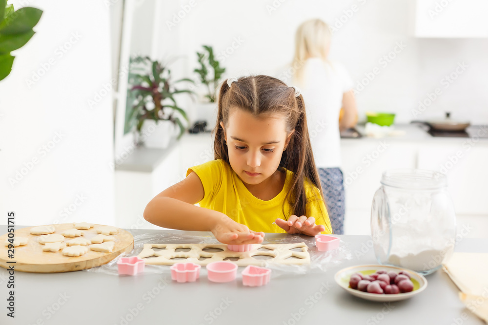little girl makes cookies from the dough in the kitchen at home little girl makes cookies from the dough in the kitchen at home