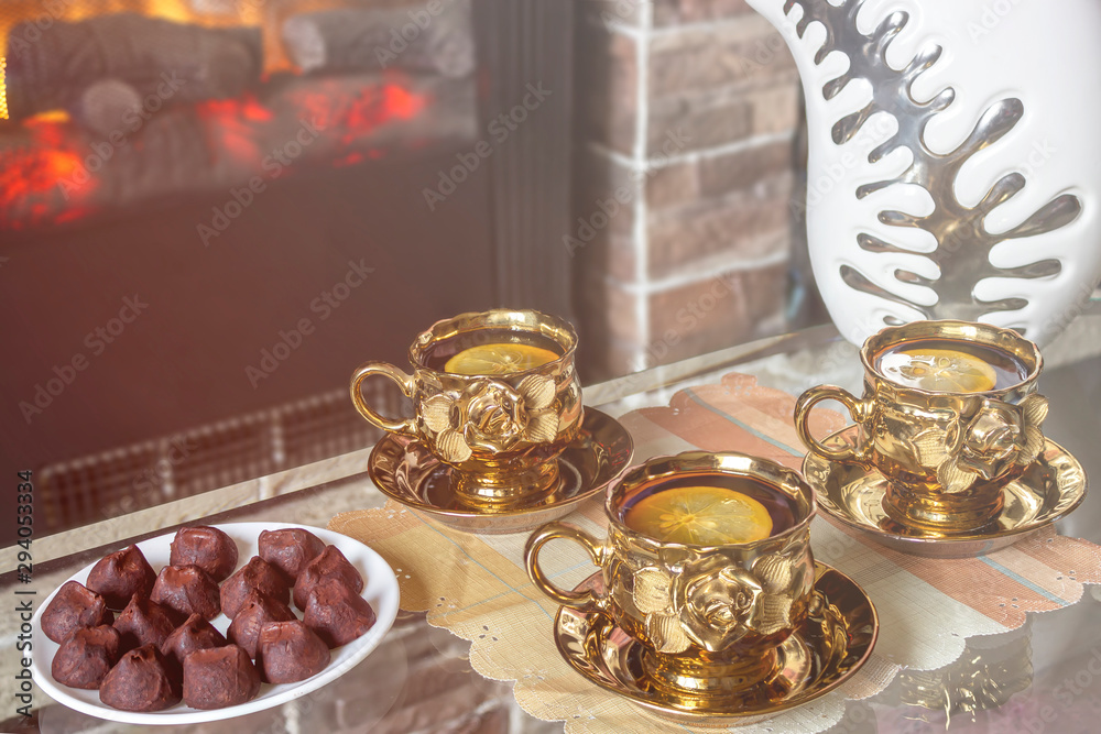 Tea with lemon and candy in front of the fireplace.