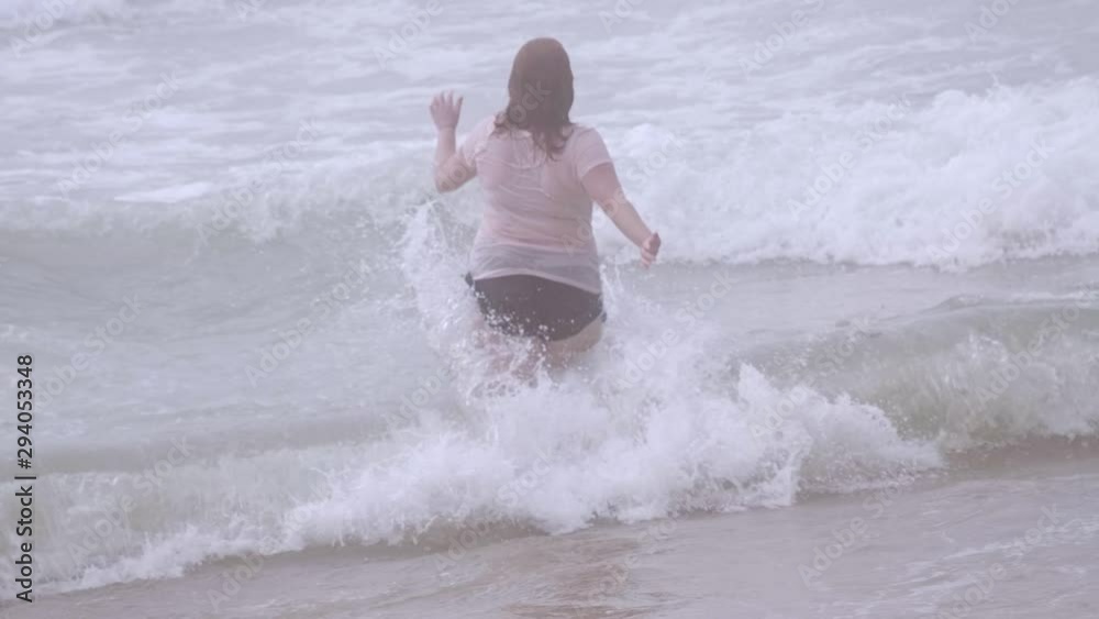 Young woman relaxes on the beach during her summer vacation - slow motion shot Young woman relaxes on the beach during her summer vacation - slow motion shot