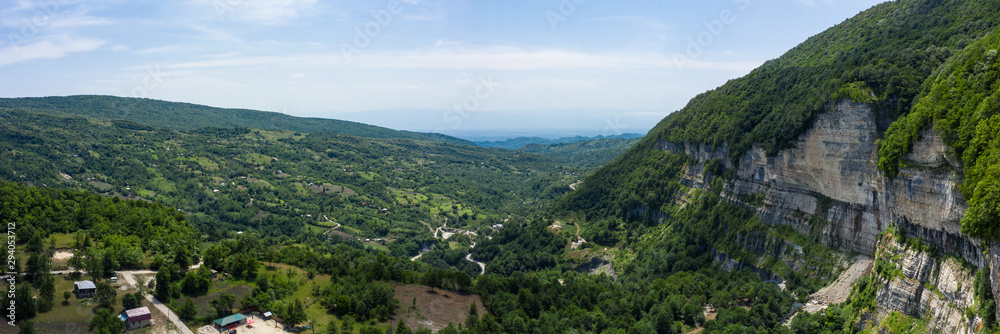 Fototapeta premium The Kinchkha waterfall in the canyon of the river Okatse. Rest in Georgia. High waterfall in the Imereti region. Rocky ledges of the mountain with green trees