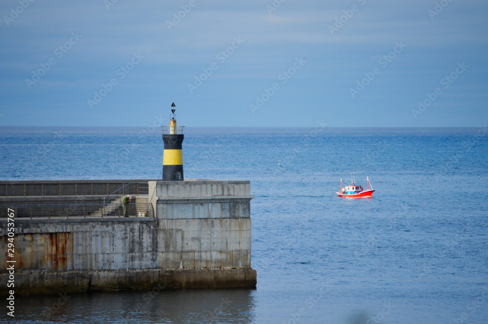 A boat arriving at Comillas harbour, Cantabria, Spain