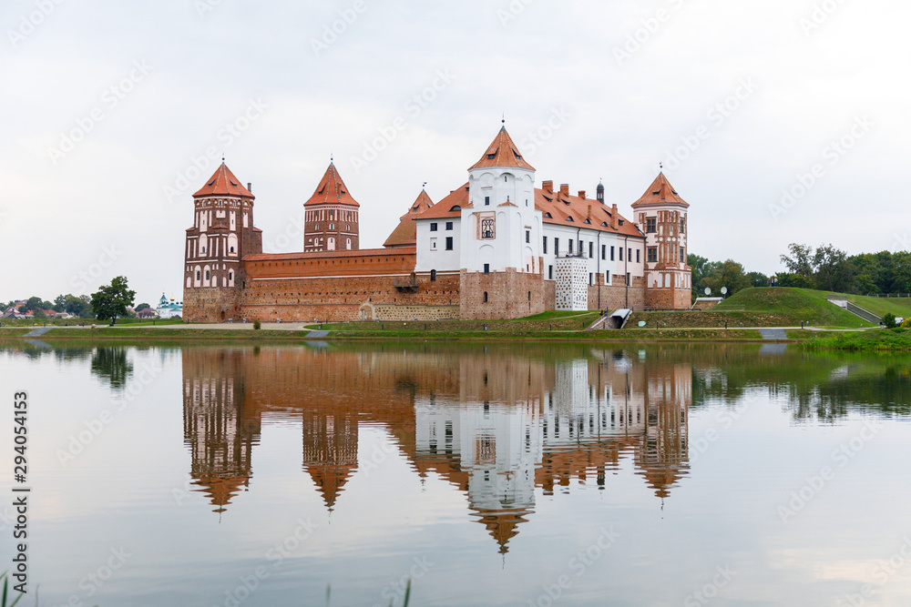 Mirsky Castle and its reflection in the lake in summer