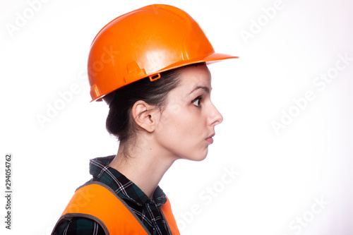 beautiful young girl builder in a helmet, portrait
