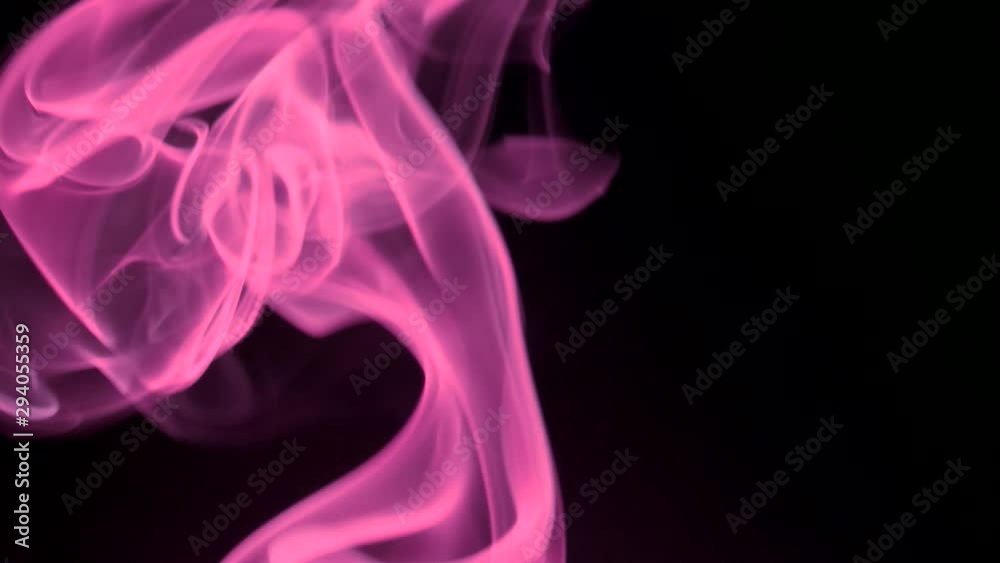 Trickle pink smoke slowly rising graceful twists upward. Colored smoke blowing from bottom to top. Close-up, isolated on black background Trickle pink smoke slowly rising graceful twists upward. Colored smoke blowing from bottom to top. Close-up, isolated on black background