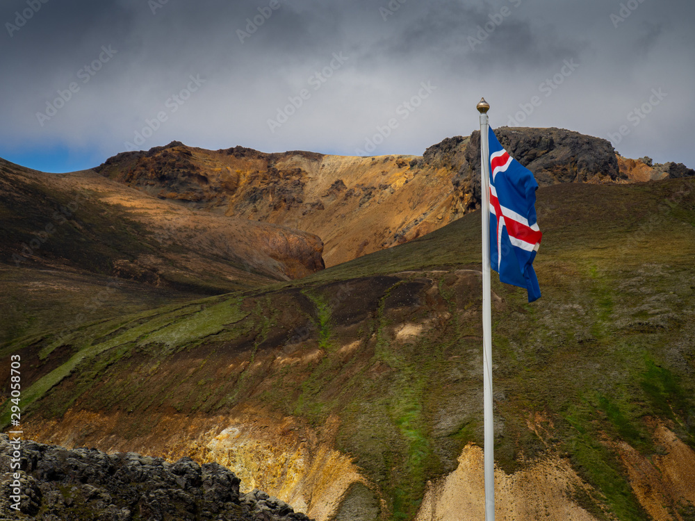 Icelandic flag against the backdrop of the Landmannalaugar mountains