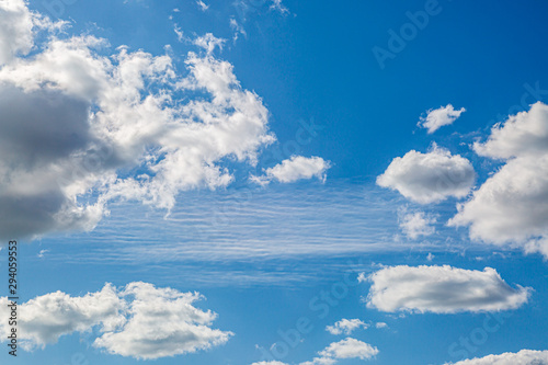 Looking up at blue sky and fluffy white clouds © lemanieh