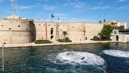 Flyboard Performance in the Taranto Canalboat in front the Aragonese Castle Decorated with Italian Flags, Souht of Italy. Slowmotion HD photo