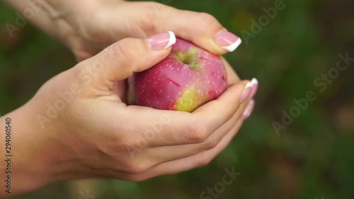  Apple in female hands, close up. Female hands wipe a ripped ripe apple, slow motion shot.