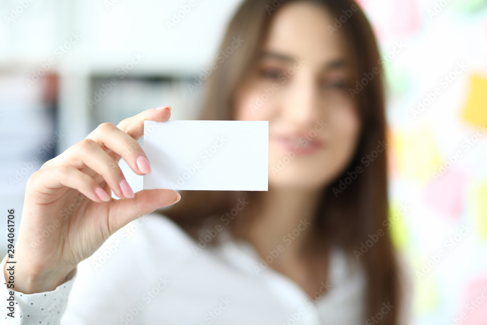 Focus on tender hand of smiling businesswoman showing special blank business card to friendly colleague or partner. Copy space on biz pasteboard. Blurred background Focus on tender hand of smiling businesswoman showing special blank business card to friendly colleague or partner. Copy space on biz pasteboard. Blurred background