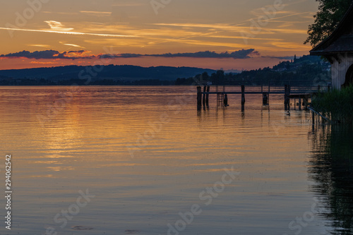 sunset at the pier in sempach with red purple blue sky on summer evening