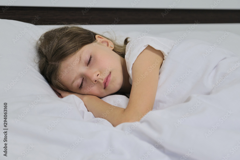 Sleeping child girl on a pillow, white bed, closeup face Sleeping child girl on a pillow, white bed, closeup face