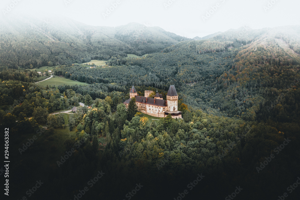 Bright autumn panorama of a Castle in a forest