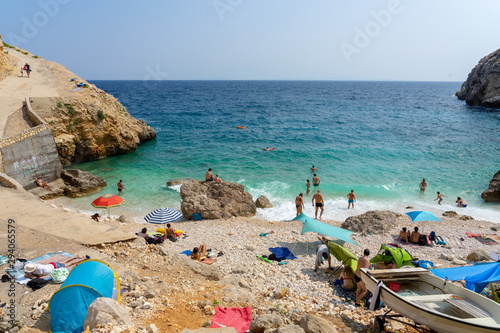 Fototapeta Naklejka Na Ścianę i Meble -  rocky scenic mali bok orlec beach on cres island croatia with unrecognisable people on the beach