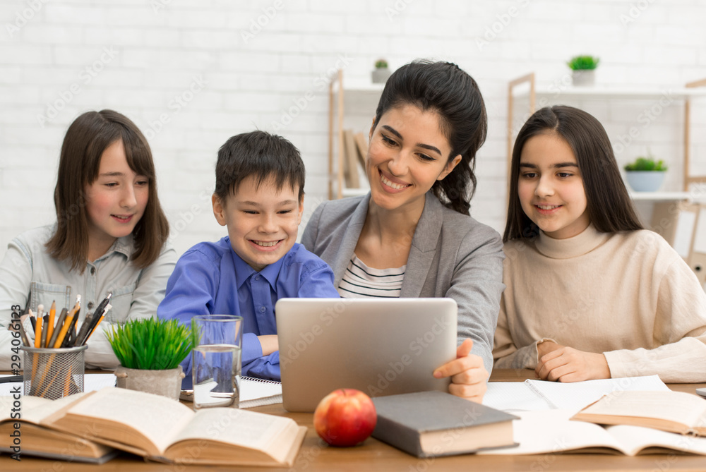 Pupils and teacher watching interesting videos on tablet Pupils and teacher watching interesting videos on tablet