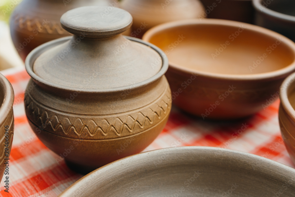 plates, cups, clay dishes close up. do-it-yourself ceramic dishes on local market. folk festival. plates, cups, clay dishes close up. do-it-yourself ceramic dishes on local market. folk festival.
